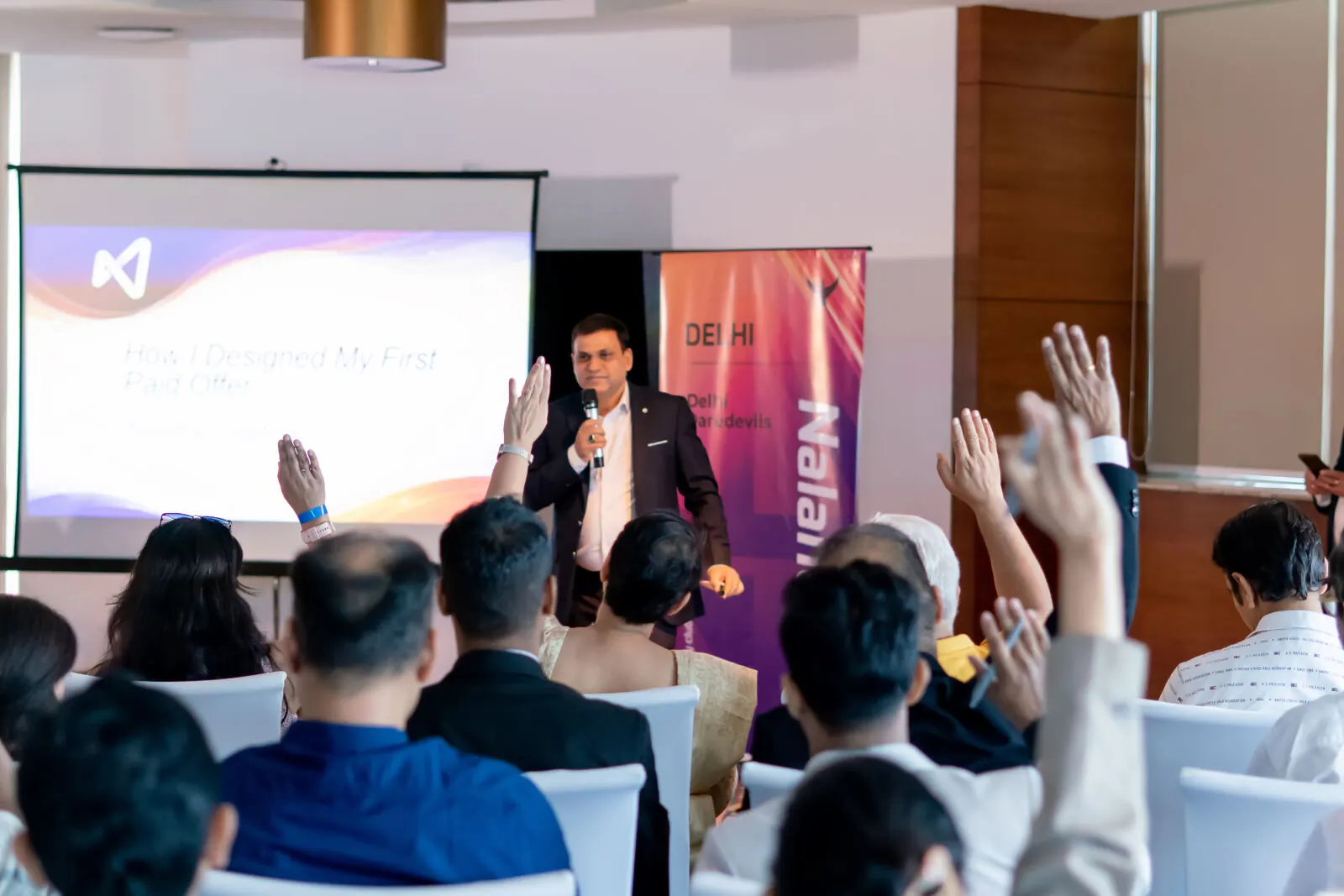 Abhishek Srivastava on stage with engaged audience raising hands